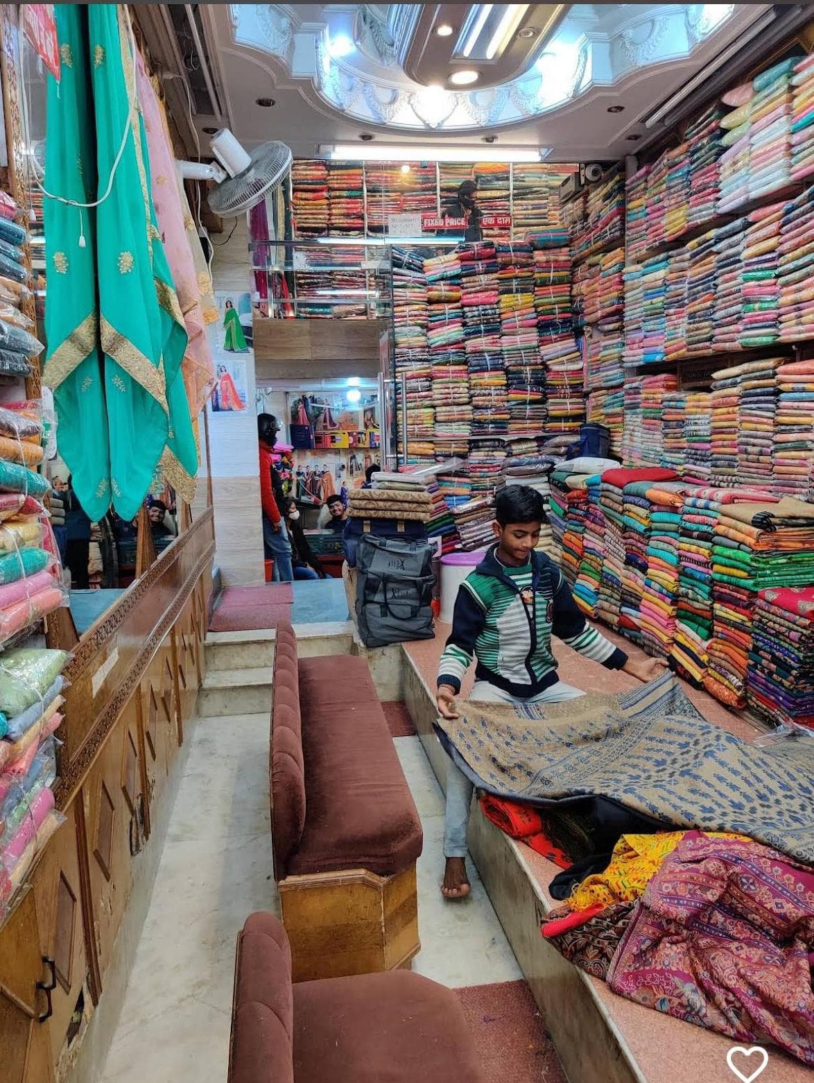 Inside the shop, a length of fabric being opened out